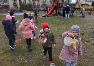 Dzieci pokazują swoje koszyczki z zebrnymi jajeczkami
