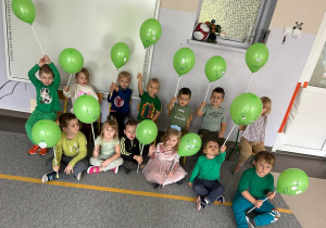 Zdjęcie grupowe dzieci z grupy II z zielonymi balonikami