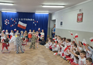 Dzieci z grupy II tańczą w parach i śpiewają piosenkę patriotyczną