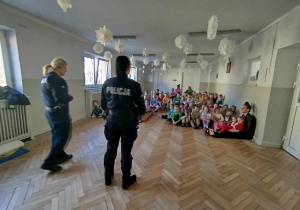 Pani Policjantki witają się z dziećmi i rozmawiają z przedszkolakami na temat bezpieczeństwa podczas drogi do przedszkola