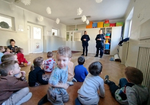 Przedszkolaki siedzą i uczestniczą w rozmowie na temat bezpieczeństwa