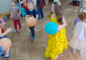 dzieci trzymają balony i uczestniczą w zabawie