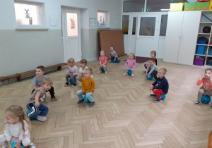Dzieci siedzą na piłkach i wykonują ćwiczenia oraz uczestniczą w zabawach