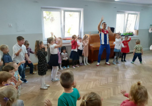 Dzieci razem z tancerzami tańczą do muzyki