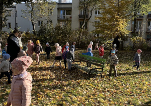 Dzieci zbierają do zielonego pojemnika ziemniaki znalezione w ogrodzie