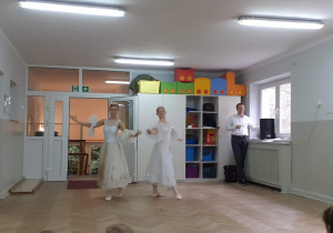 Dwie tancerki w białych sukienkach tańczą dla dzieci
