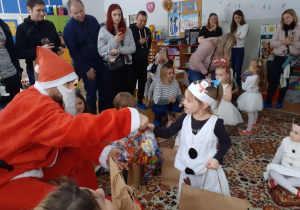 Mikołaj rozdaje dzieciom prezenty