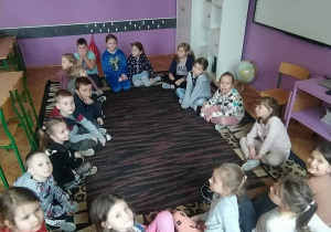 Dzieci siedzą na dywanie