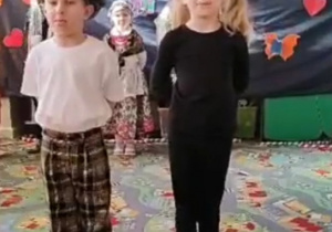 Dziewczynka i chłopiec mówi wierszyk w tle stoją dzieci