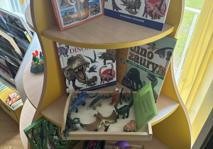 kącik tematyczny z przedmiotami, zabawkami, stempelkami i książkami o dinozaurach