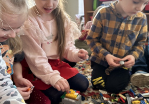 Dzieci przemieniają Genibota w dinozaura za pomocą klocków lego