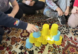dzieci układają wieże z kubków według wzoru w zespołach