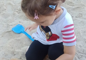 Dziewczynka robi babke z piasku