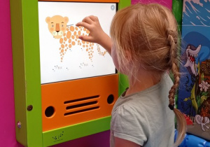 Dziewczynka rysuje na tablicy interaktywnej