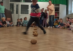 Chłopiec wykonuje slalom między ziemniakami