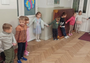 Dzieci stoją w kole trzymając się za ręce i bawią się w zabawę "Ziemniaczku mój malutki""