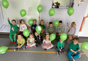 Zdjęcie grupowe dzieci z grupy II z zielonymi balonikami