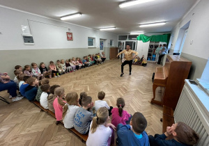Dzieci oglądają taniec rumbę w wykonaniu instruktora