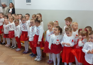 Dzieci na stojąco śpiewają piosenkę
