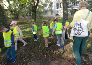 Dzieci chodzą w okolicy przedszkola i zbierają śmieci
