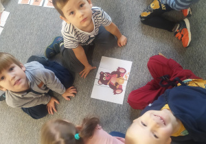 Dzieci pracuja w małych zespołach - układają misiowe puzzle