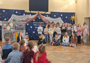 Uczniowie opowiadają o Bożym Narodzeniu i śpiewają kolędy.