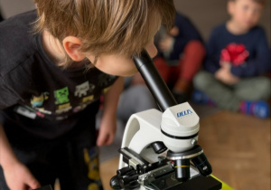 Dziecko patrzy przez mikroskop