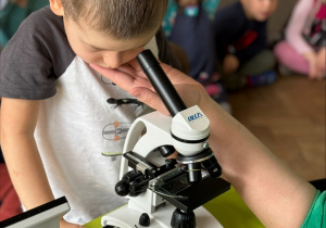 Dziecko patrzy przez mikroskop