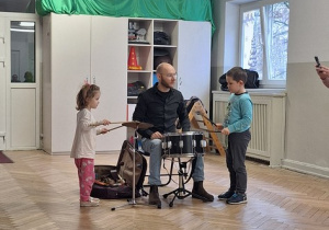 Dzieci grają wspólnie z muzykiem na instrumentach