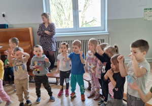 Dzieci stoją i śpiewają piosenkę z pokazywaniem