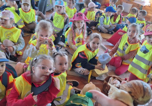 Dzieci siedzą i słuchają informacji o ślimaku