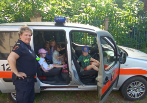 Dzieci siedzą w samochodzie Straży Miejskiej
