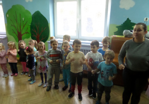 Dzieci stoją po kole i tańczą