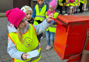 Dziecko wrzuca swój list do skrzynki pocztowej