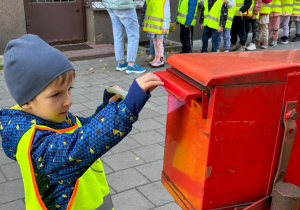 Dziecko wrzuca swój list do skrzynki pocztowej