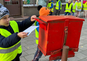 Dziecko wrzuca swój list do skrzynki pocztowej