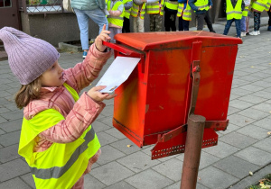 Dziecko wrzuca swój list do skrzynki pocztowej