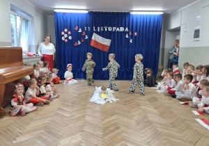 Chłopcy w strojach żołnierzy chodza po scenie - odegranie sceny odzyskania Niepodległości przez Polskę