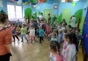 Dzieci tańczą z prowadzącymi wg ich pokazu.