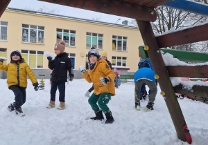 Dzieci rzucają kulkami ze śniegu do celu