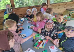 Dzieci malują farbami gipsowe odlewy owadów
