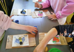 Dzieci malują farbami gipsowe odlewy owadów