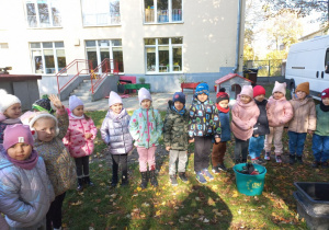 Dzieci stoją i słuchają informacji o alpakach