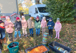 Dzieci stoją i słuchają informacji o alpakach