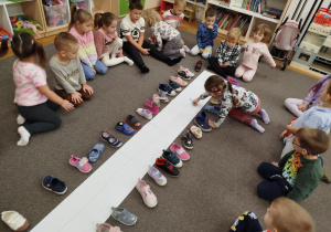 Dzieci mazakiem łączą w pracy swoje buciki