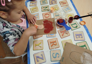 Dziewczynka maluje grzybek farbą