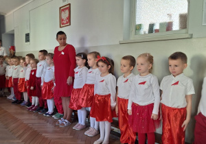 Dzieci na stojąco śpiewają piosenkę o Polsce