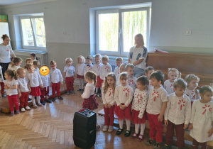 Dzieci na stojąco śpiewają piosenkę o Polsce