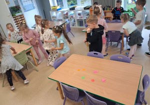 Dzieci szukają ukrytych kropek w sali