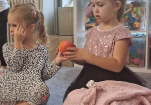 Dziewczynki podają sobie dynię